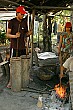 Metal workers power the bellows to keep the flames hot.