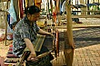 Working an old fashioned loom to produce colourful silk textiles.
