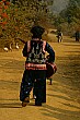 This guitar-toting villager strolls down the path singing Lao songs.