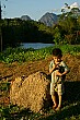 This young boy plays with his chicken.
