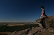 Jen takes a break to view the valley below against a solid blue sky.